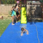 A tarp and sprinkler will create a fun splash pad for a slide