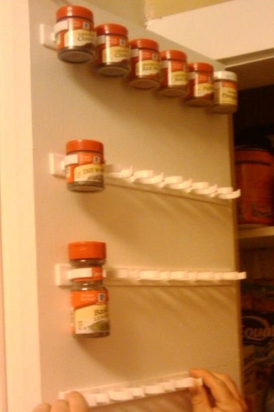 Great Kitchen Storage Ideas---Use a mop holder to store spices on the inside of a cabinet door.