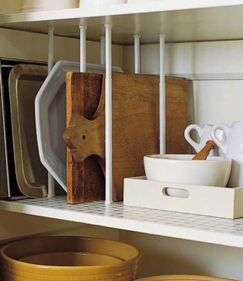 Storing baking sheets, cutting boards, and sturdy platters upright on kitchen shelves frees space and keeps you from having to lift a heavy stack.